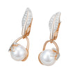 Rose gold crystal flower pearl drop earrings showcased on a jewelry stand, featuring sparkling zircon leaves and round pearls.