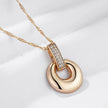 Rose gold pendant necklace with crystal-embellished bail, displayed on a light beige background