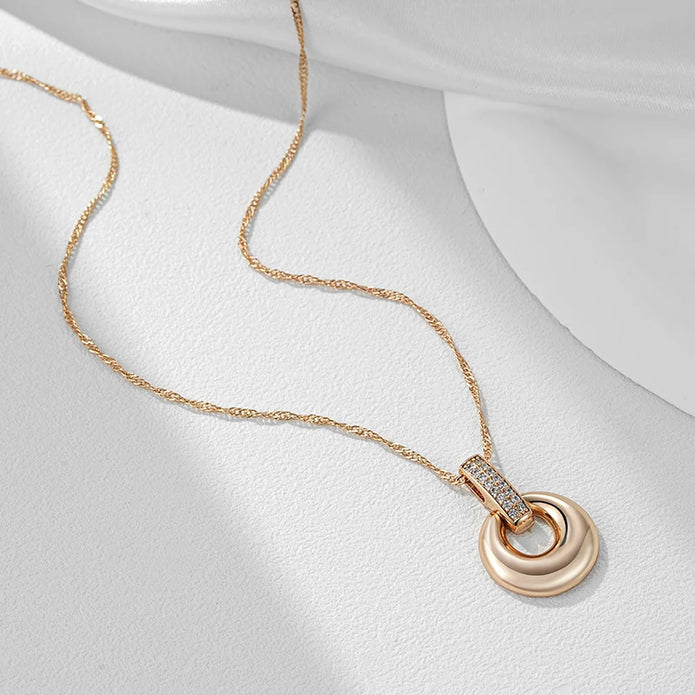 Rose gold pendant necklace displayed flat with a twisted chain on a white surface