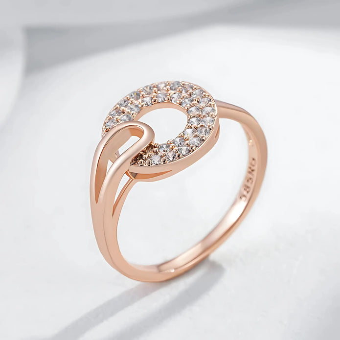 Rose gold ring with diamond accents on a light gray background