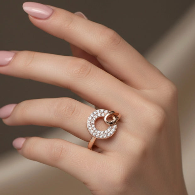 Rose gold ring with diamonds on a hand against a neutral background