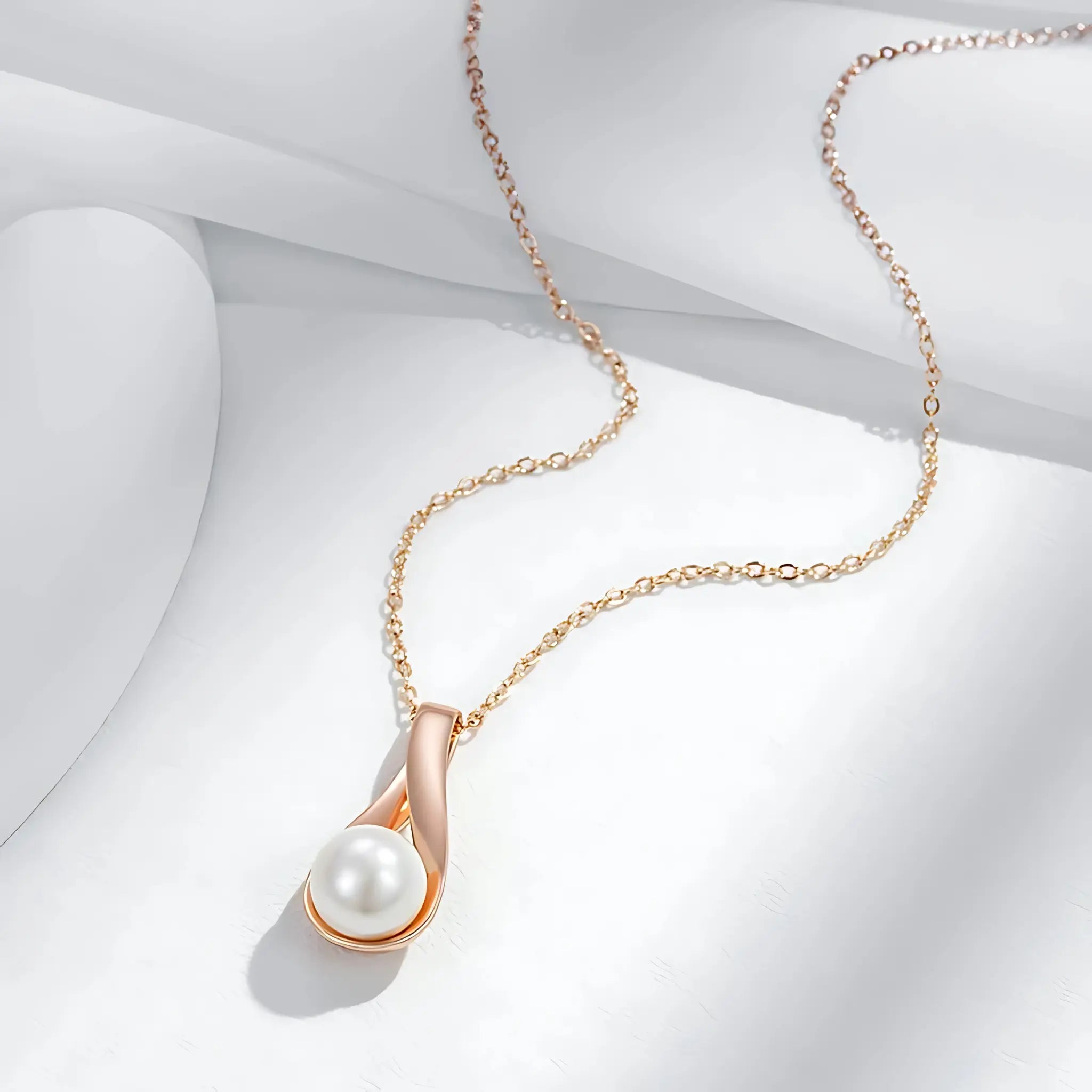 Gold necklace with a pearl pendant on a white background
