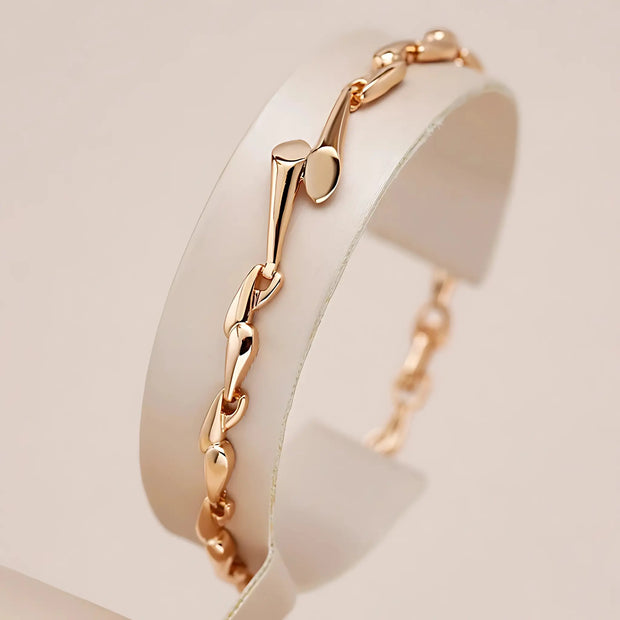Rose gold bracelet on a white stand with a soft beige background