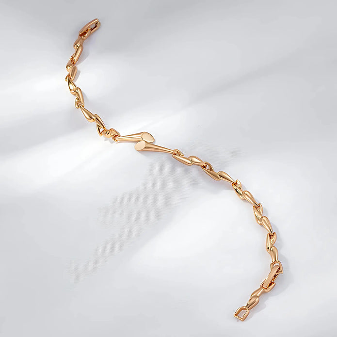 Gold chain bracelet on a light gray background