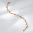 Gold chain bracelet on a light gray background