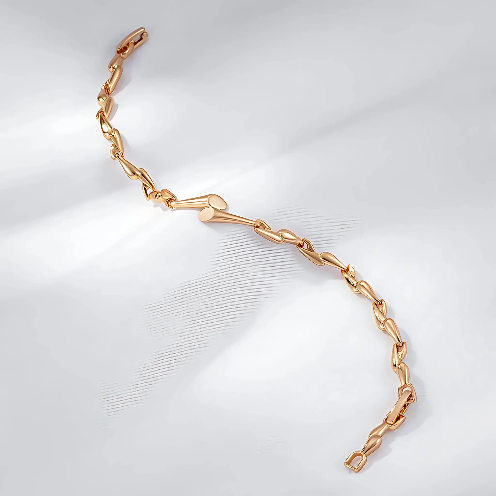 Gold chain bracelet on a light gray background