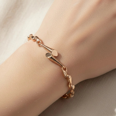 Rose gold bracelet on a wrist against a neutral background