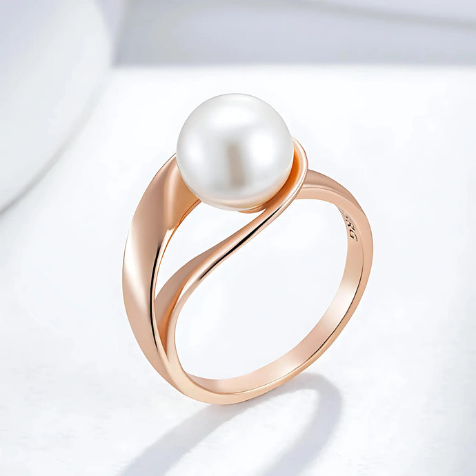 Rose gold ring with a pearl on a light gray background