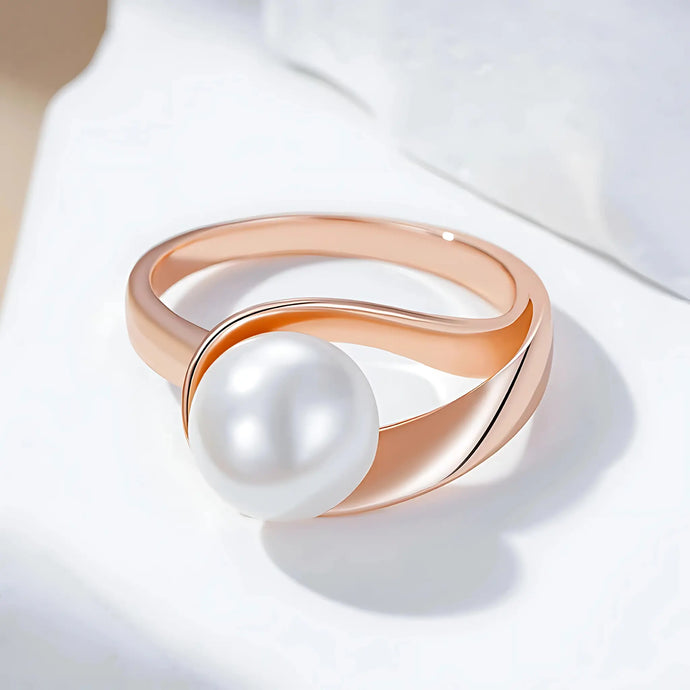 Rose gold ring with a pearl on a white background