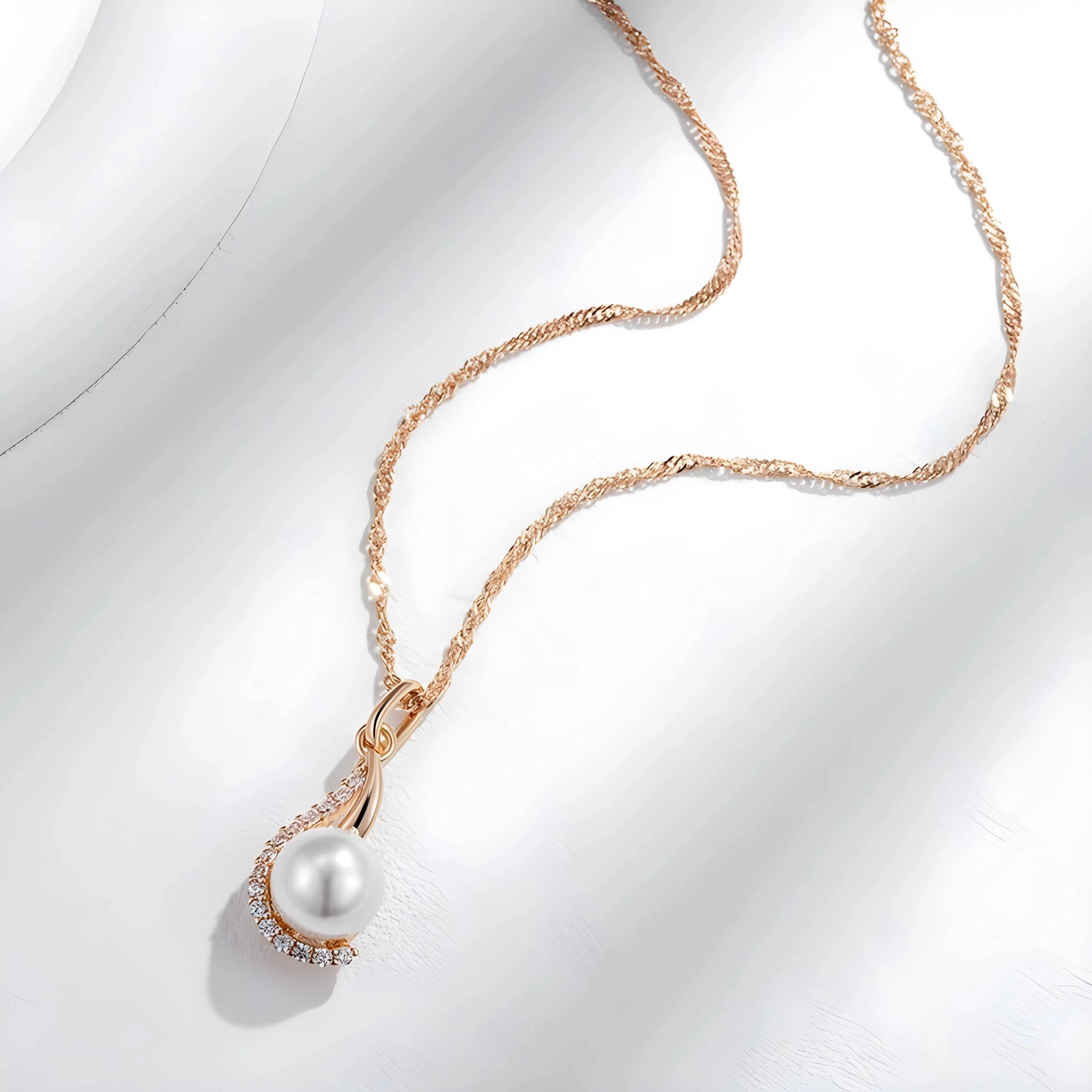 Pearl necklace with rose gold chain on a white background