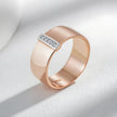 Rose gold ring with diamond accent on a light gray background