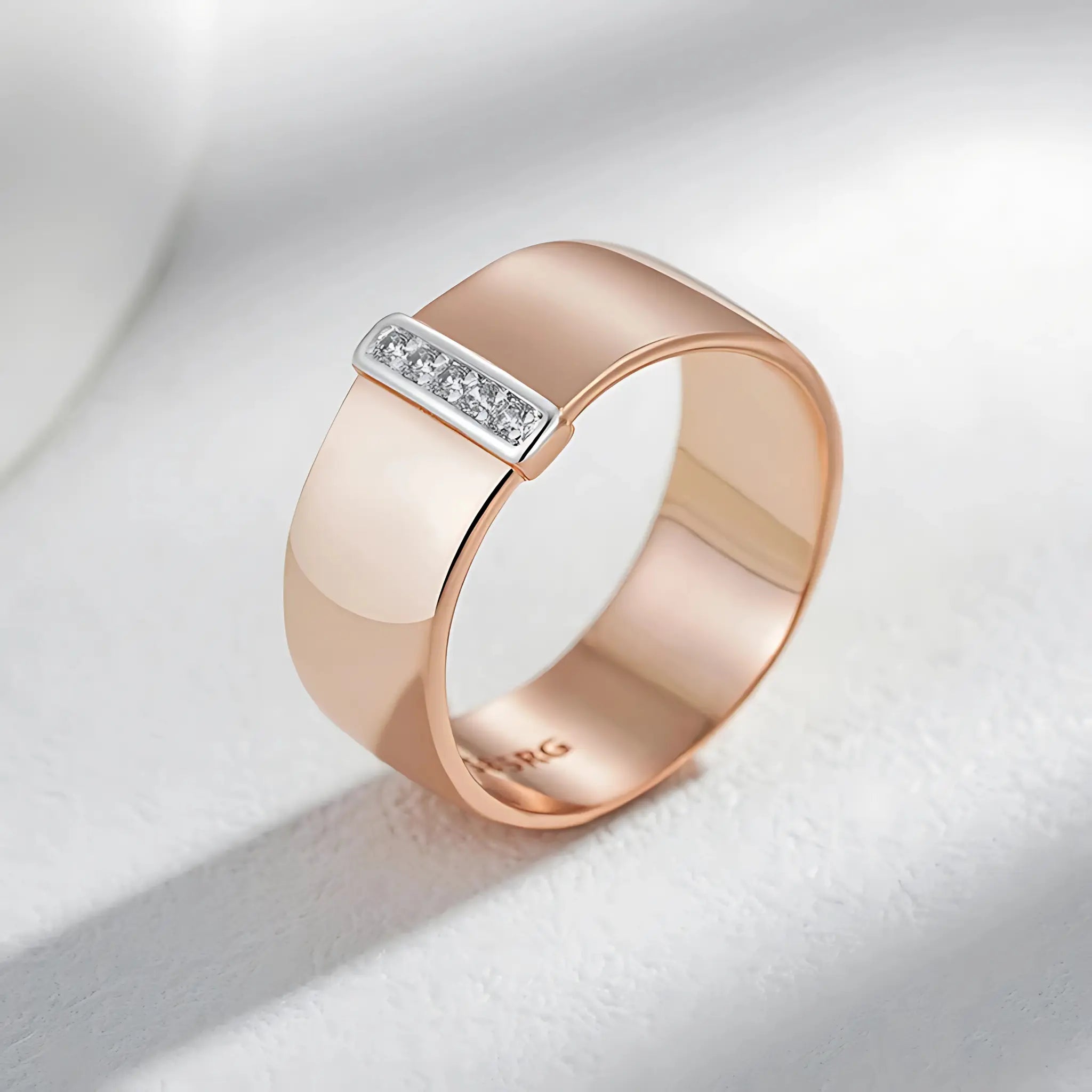 Rose gold ring with diamond accent on a light gray background