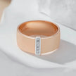 Rose gold ring with diamond accents on a light background
